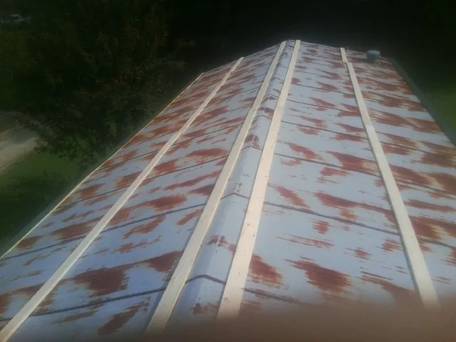 Rusted metal roof panels with new wood purlins before replacement — Storm Damage Roof Repair in Cornish by Roofing Brothers