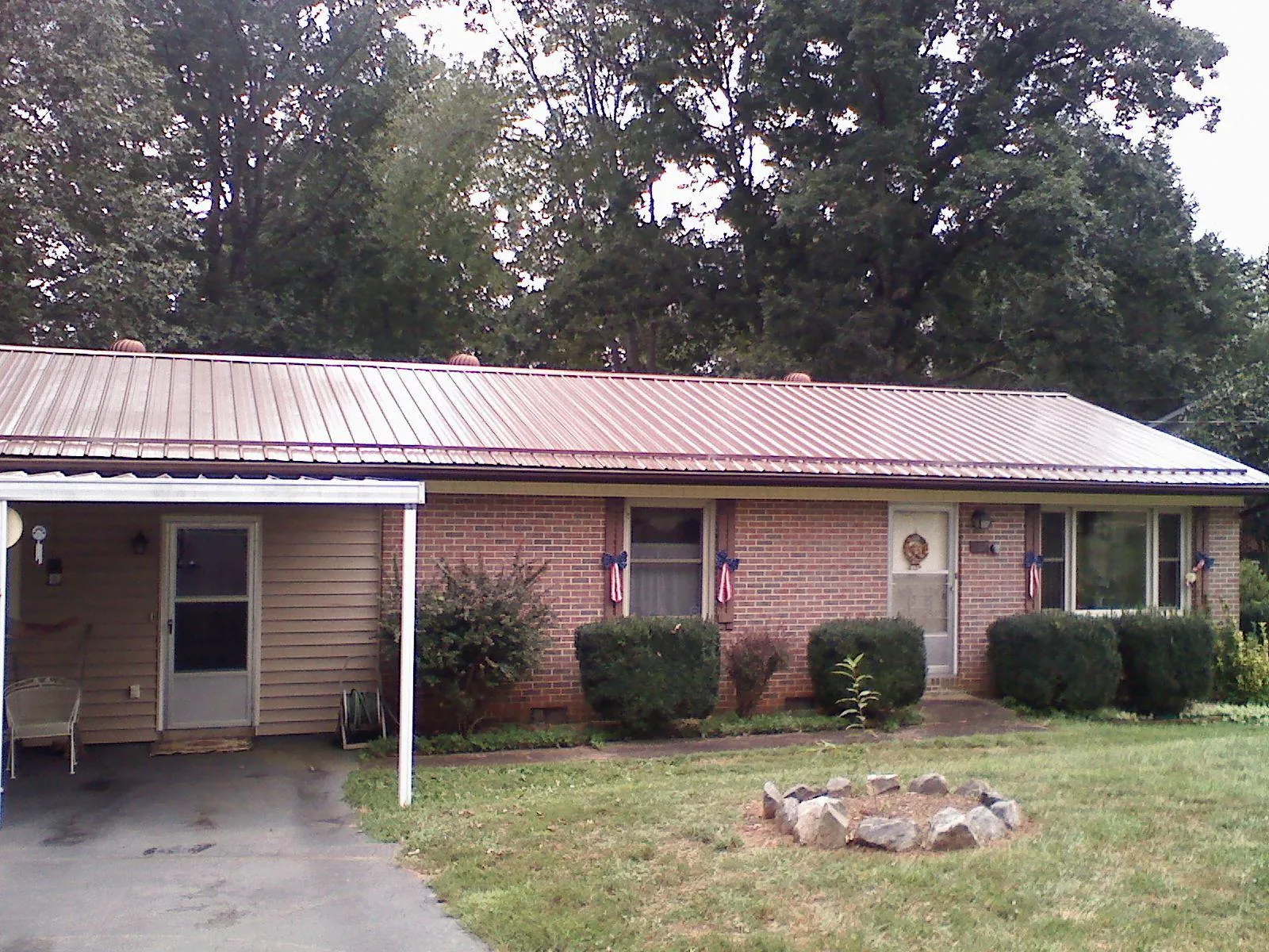 Bronze metal roof and carport on a brick ranch home — Roof Repair work by our crew in Cornish